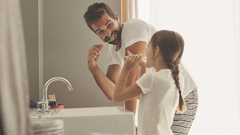 Vater und Tochter beim Zähneputzen